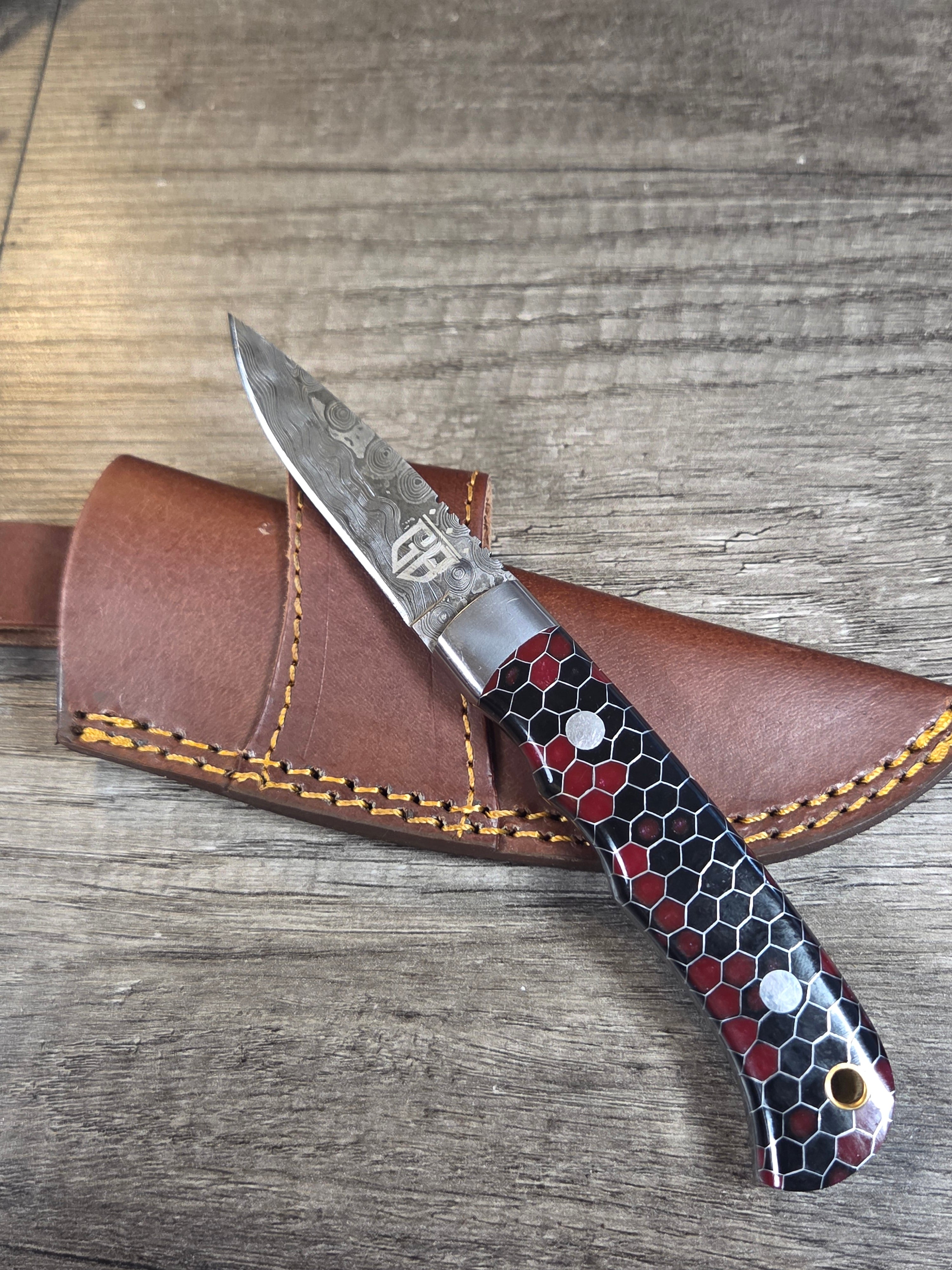 7" overall, 3" blade. Honeycomb black and red handle. Raindrop San mai Damascus blade